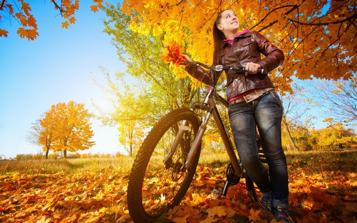 Woman with bicycle in autumn park