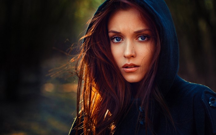 Woman with red hair and blue eyes wearing a hood
