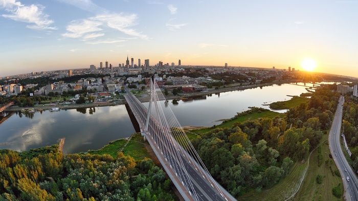 Warsaw cityscape with Vistula River and bridge at sunset