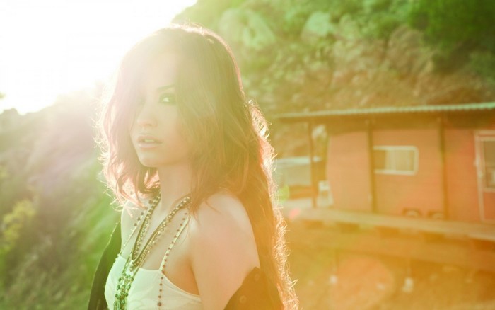 Demi Lovato in sunlight near a building