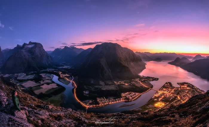 Mountainous landscape with river and town at sunset