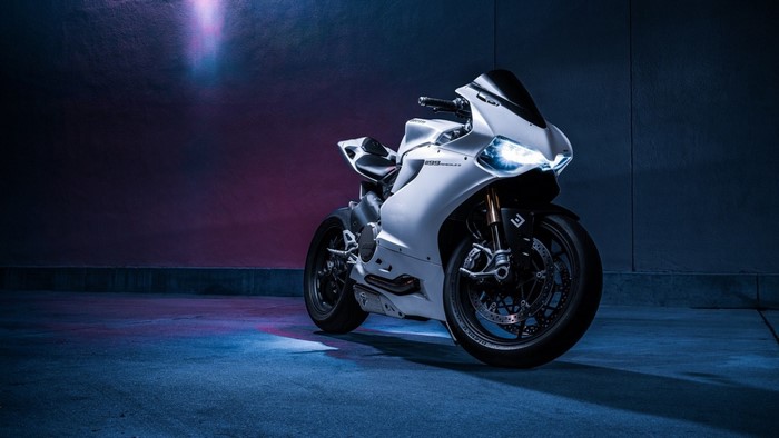 White Ducati motorcycle with headlights on