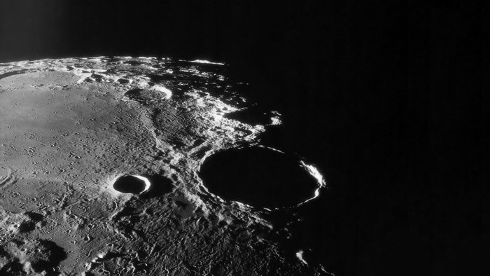 Lunar surface with craters and Earth in the background