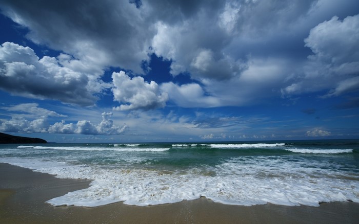 Beach with waves and dramatic clouds