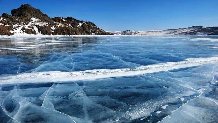 Frozen Lake with Mountains and Clear Blue Sky