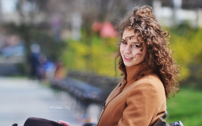 Woman with curly hair in a brown coat