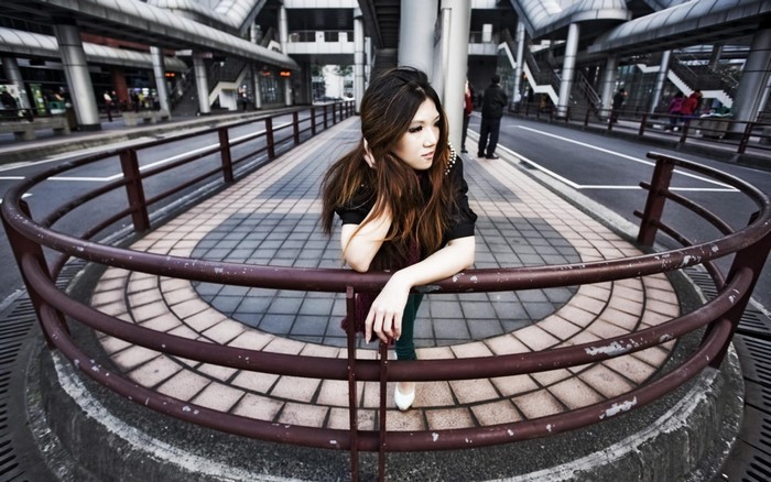 Asian woman posing behind a railing