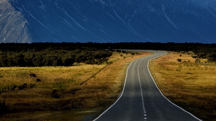 Winding road through a rural landscape with mountains