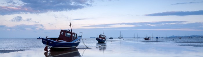 Boats moored on a calm sea at dusk
