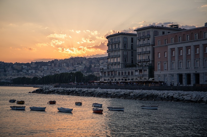 Sunset over the coast of Napoli, Italy with boats