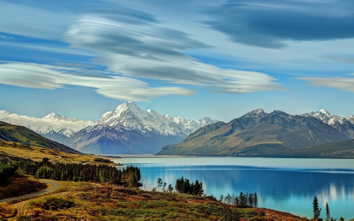 Lake reflection of snow-capped mountains and clouds