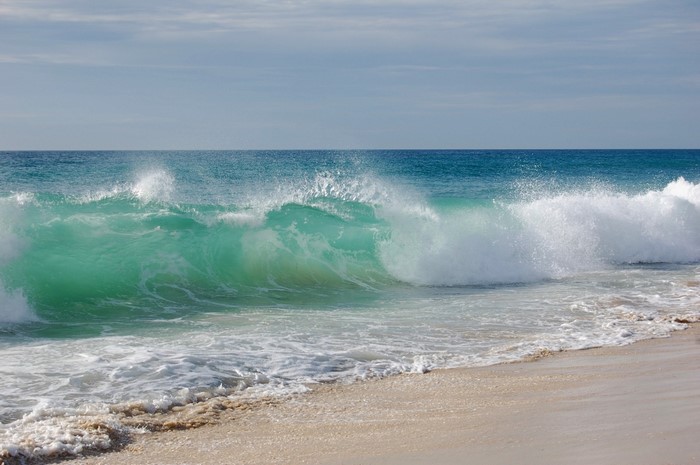 Ocean wave crashing on a sandy beach