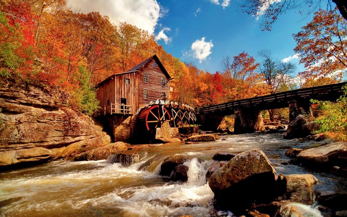 Old mill and bridge in autumn by a river