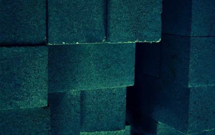 Stack of dark teal bricks with rough texture