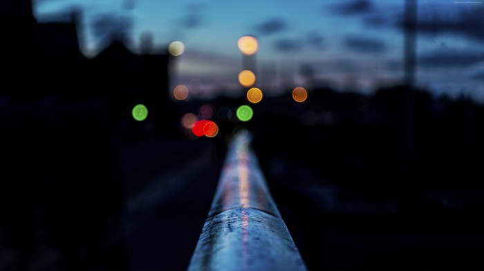 Bokeh lights on a railing at night