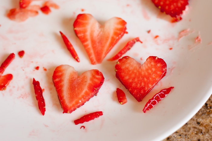 Heart-shaped strawberry slices on a white plate