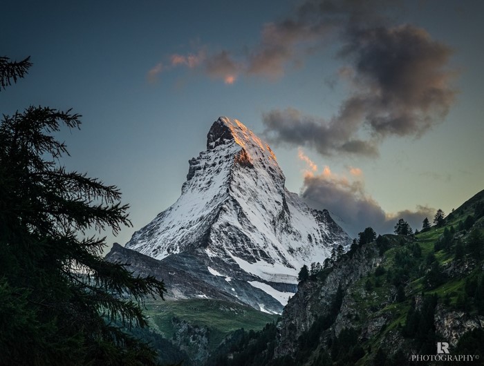 Matterhorn mountain at sunrise with clouds and trees