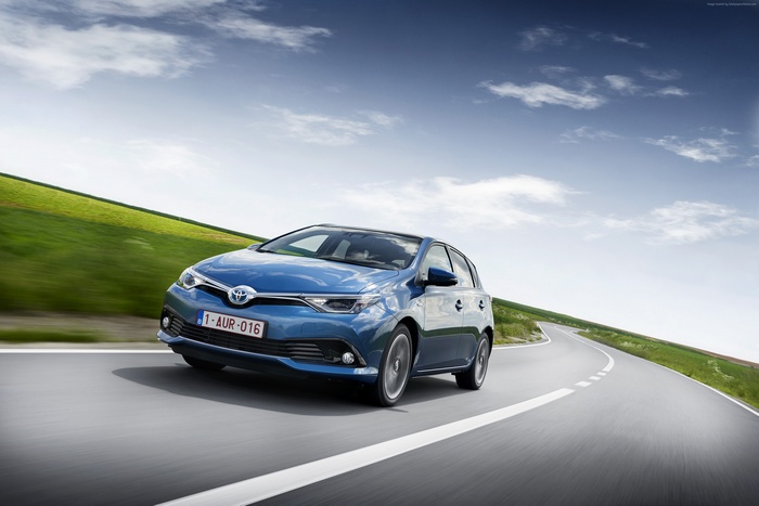 Blue Toyota Auris Hybrid hatchback driving on a road