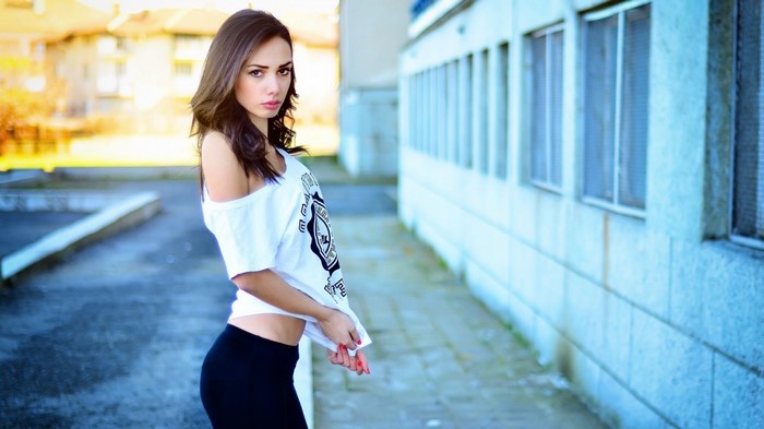 Woman in white shirt and black pants posing outdoors
