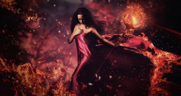 Sorceress with fiery staff in darkness