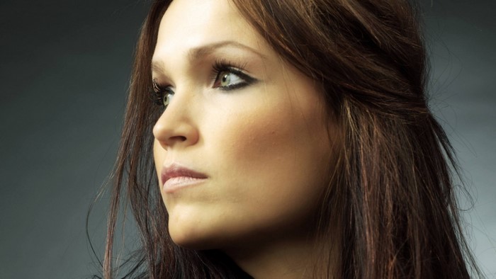 Portrait of Tarja Turunen, a woman with long brown hair and green eyes
