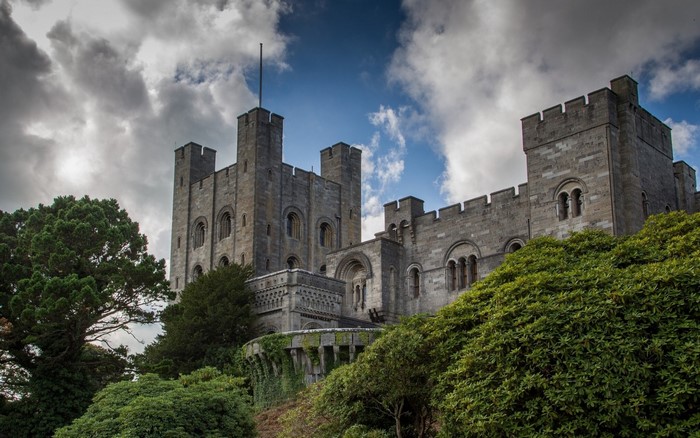 Castle on a hill with trees and cloudy sky