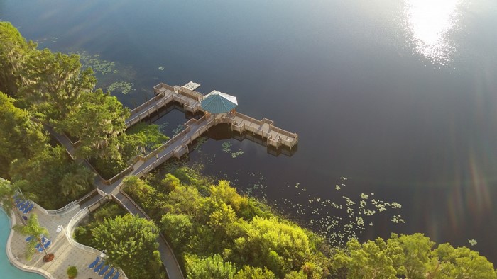Aerial view of a wooden pier on a lake surrounded by trees