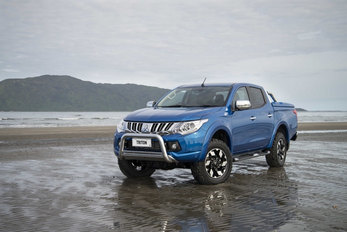 Blue Mitsubishi Triton pickup truck on a beach