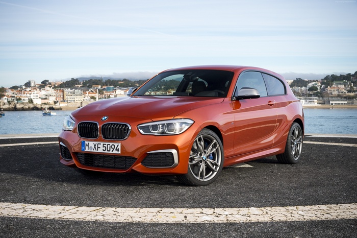 Orange BMW M135 hatchback parked by the water