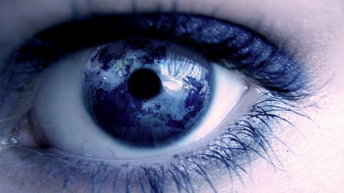 Close-up of a human eye reflecting the Earth