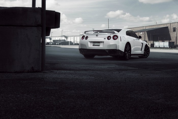 White Nissan GT-R R35 parked near industrial buildings