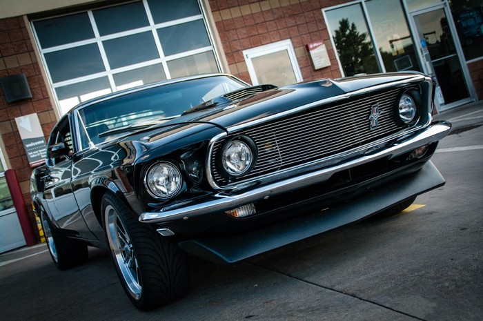 Black 1969 Ford Mustang Mach 1 parked outside building