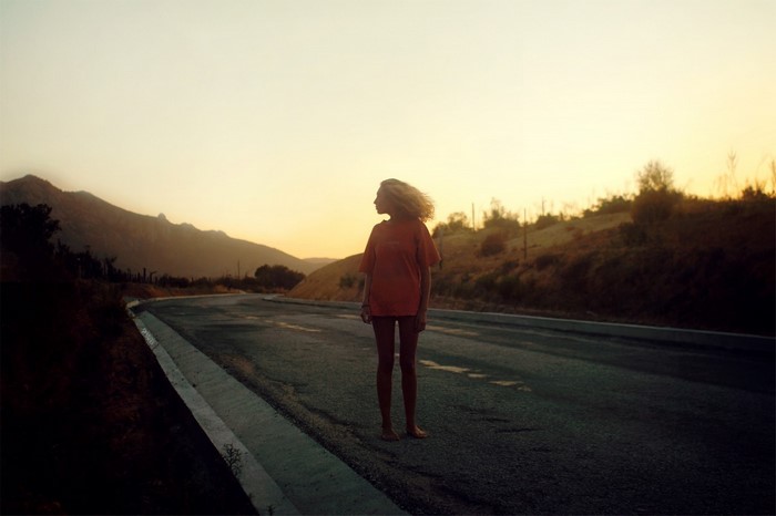 Girl on a road at sunset