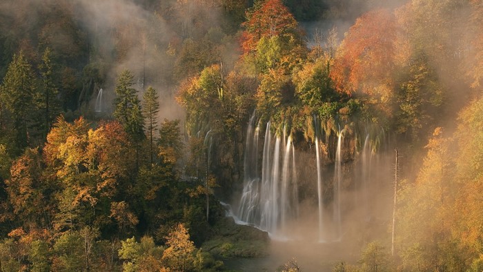Autumn waterfall in a misty forest