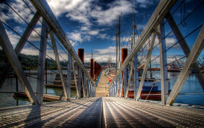 Pier walkway with boats docked in a harbor