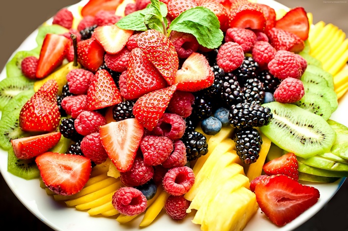 Assorted fresh berries and sliced fruits on a platter