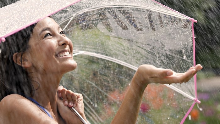 Smiling Woman Enjoying Rain with Transparent Umbrella