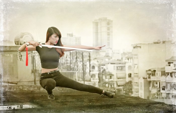 Asian woman with sword on rooftop