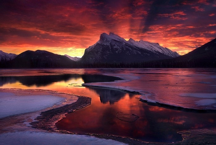 Sunset over a frozen lake with mountains in Banff National Park