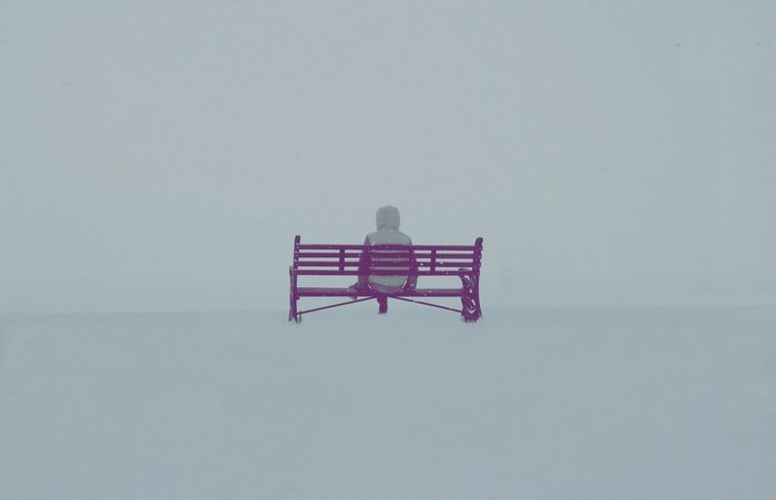 Person sitting on a bench in the snow