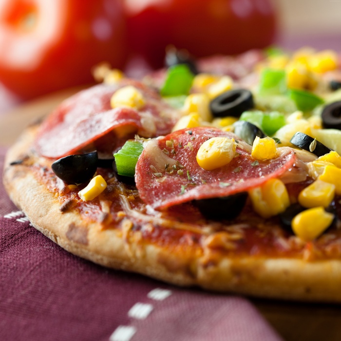 Pizza with salami, olives, and corn
