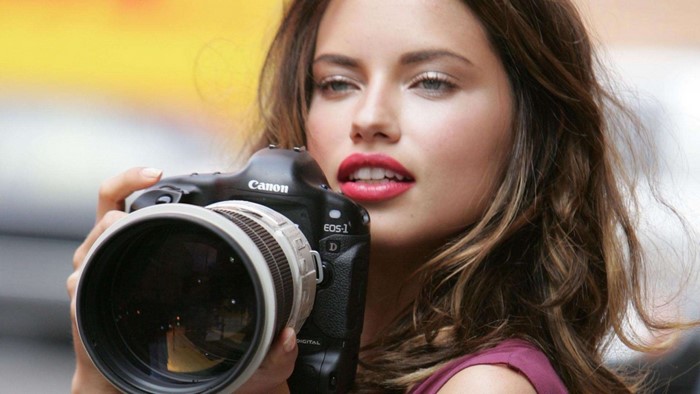 Adriana Lima holding a Canon EOS-1D camera
