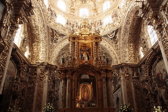 Ornate golden interior of a Mexican church with an altar
