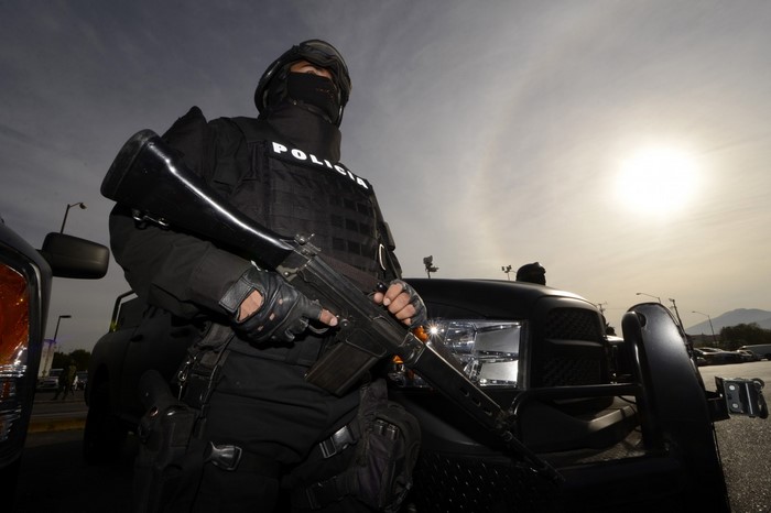 Police officer with rifle and tactical vehicle