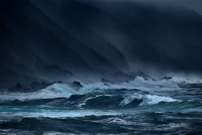 Stormy ocean waves crashing against rocky coast