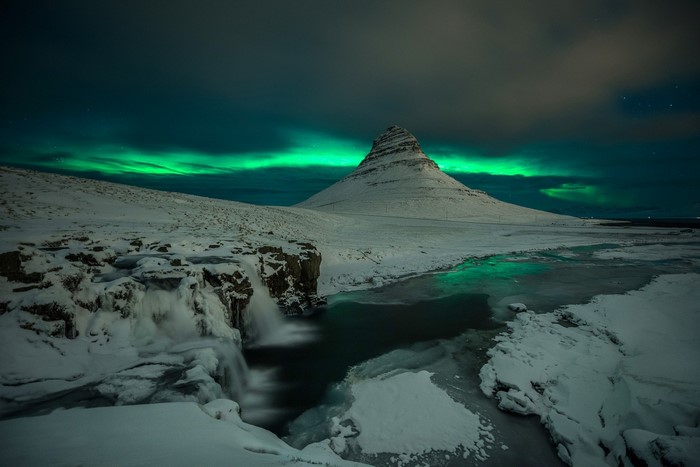Aurora Borealis Over Snow-Covered Mountain and Frozen River