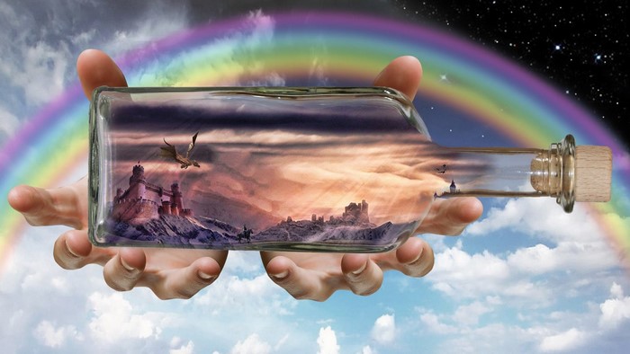 Fantasy landscape in a bottle held by hands