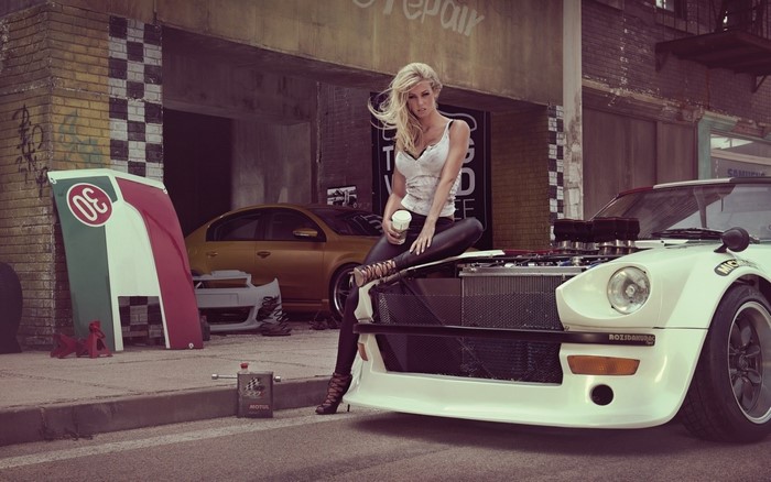 Woman in leather pants sitting on a sports car