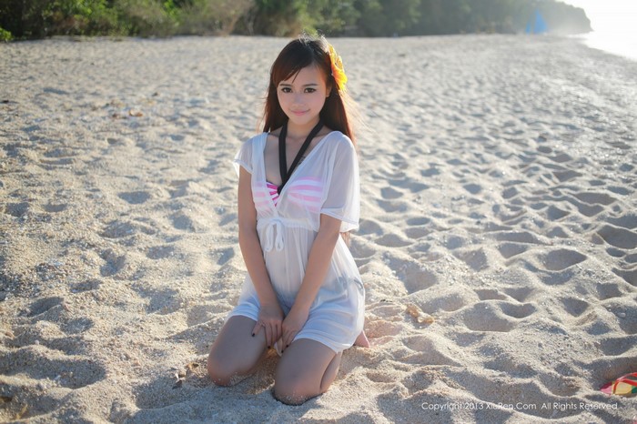 Asian woman in white dress on a sandy beach