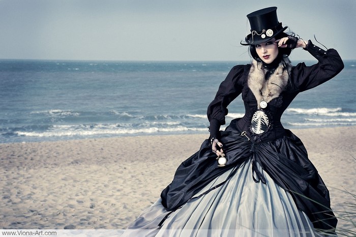 Steampunk lady with watch on beach
